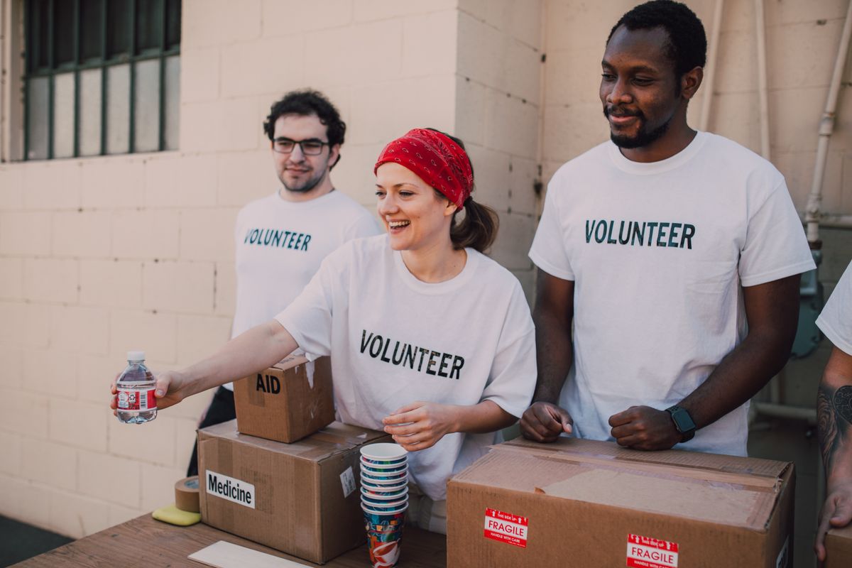 A diverse group of volunteers in matching shirts working side by side at a community event