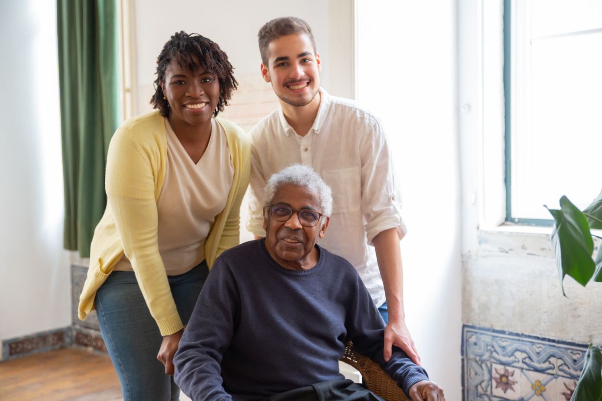Three people of different ages relaxed together in a sunlit living room